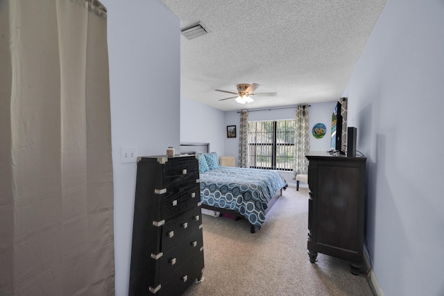 carpeted bedroom featuring a textured ceiling and ceiling fan