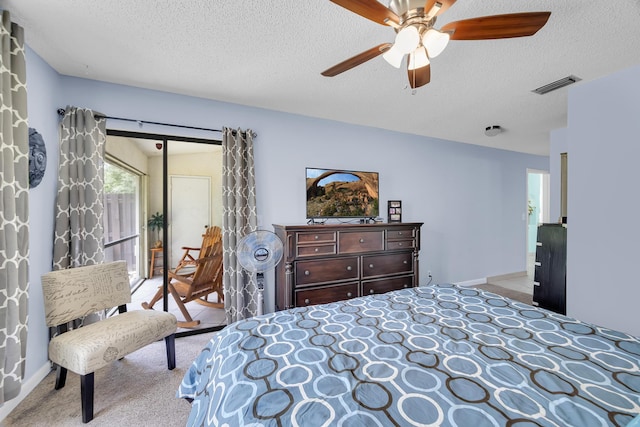 bedroom with carpet, a textured ceiling, and a ceiling fan