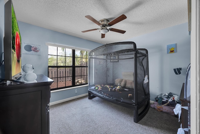 bedroom featuring carpet, a ceiling fan, a textured ceiling, and baseboards