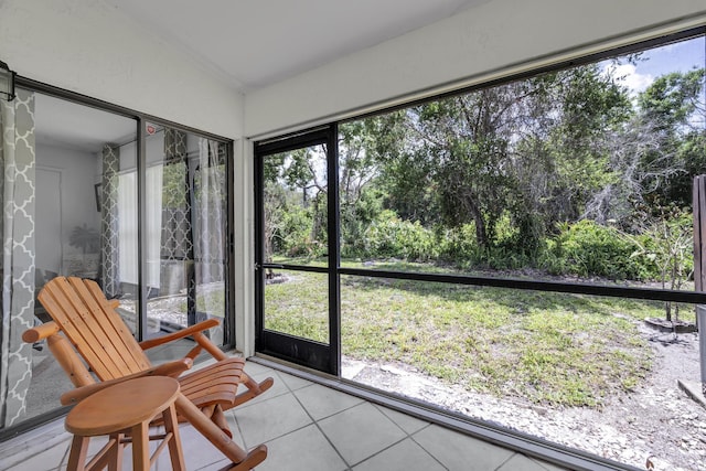 sunroom with healthy amount of natural light and view of wooded area