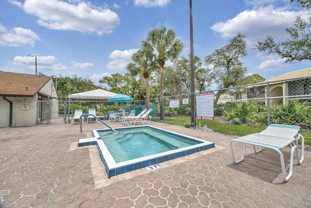 view of swimming pool featuring a gate, fence, a pool, and a patio