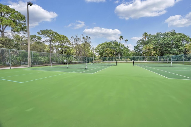 view of tennis court featuring fence and community basketball court