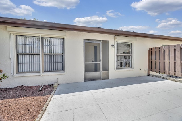back of house featuring a patio, stucco siding, and fence