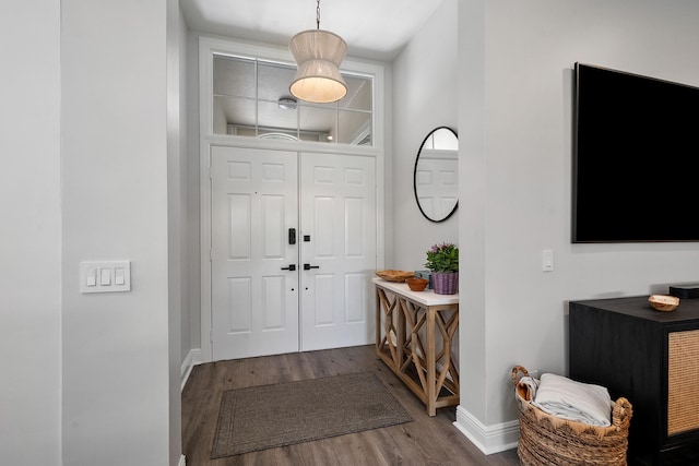 foyer featuring wood finished floors and baseboards