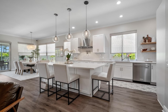 kitchen featuring stainless steel dishwasher, wall chimney exhaust hood, light countertops, white cabinets, and backsplash
