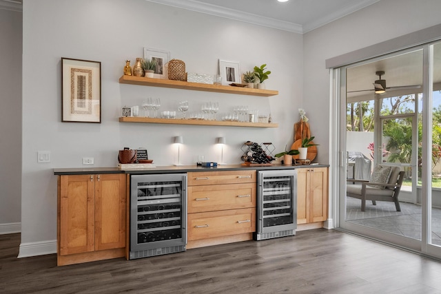 indoor bar featuring wine cooler, dark wood-type flooring, crown molding, and baseboards