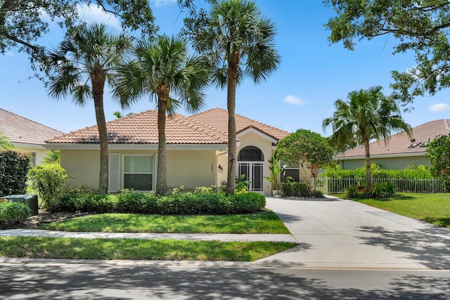 mediterranean / spanish-style home featuring a tile roof, stucco siding, and driveway
