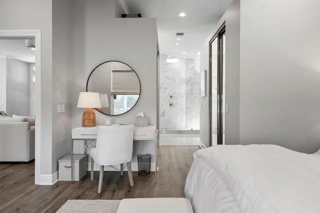 bedroom featuring wood finished floors, recessed lighting, baseboards, and ensuite bath