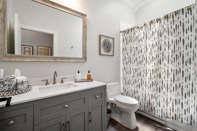 bathroom featuring toilet, wood finished floors, vanity, a shower with curtain, and ornamental molding