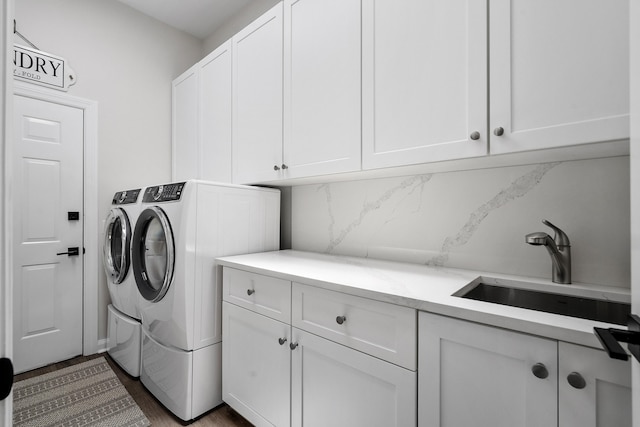 laundry room featuring cabinet space, independent washer and dryer, and dark wood-type flooring