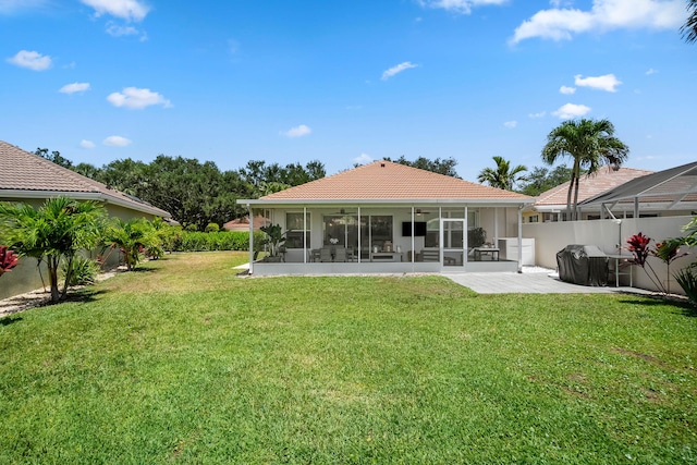 rear view of house with a sunroom, a ceiling fan, and a tiled roof