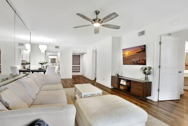 living area with wood finished floors, ceiling fan, and baseboards