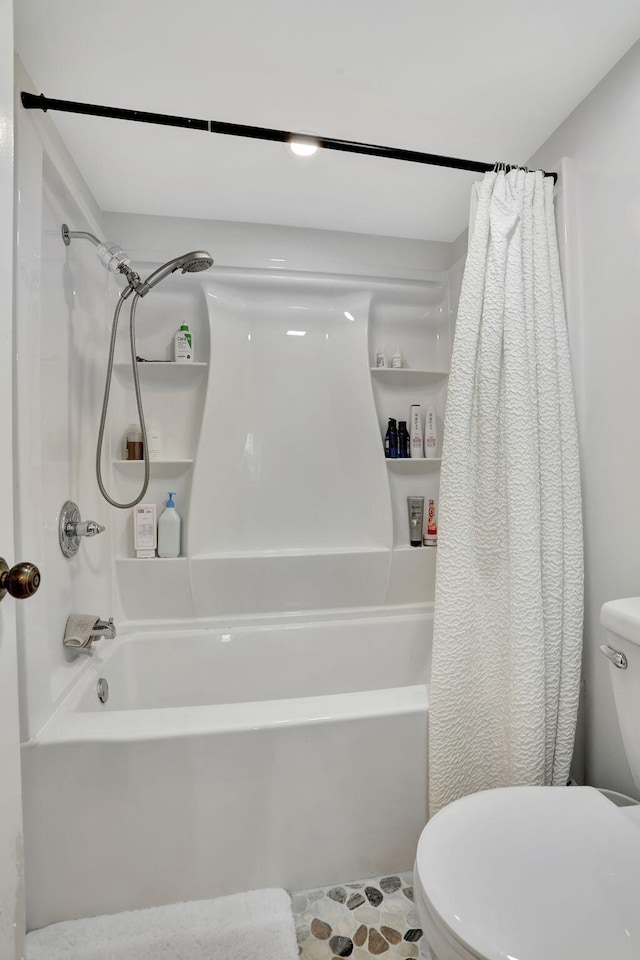 bathroom featuring toilet and shower / bath combination with curtain