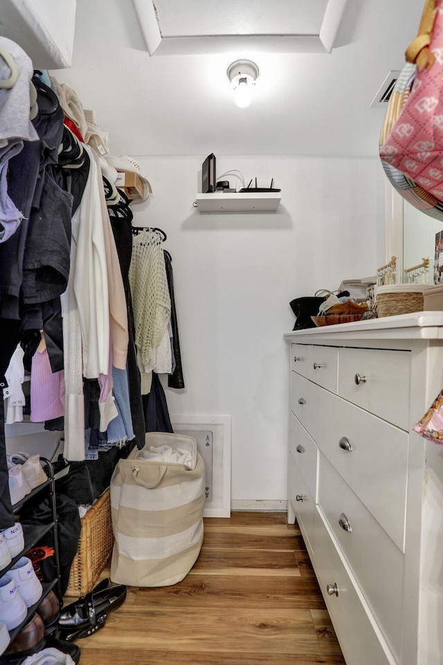 walk in closet with light wood-style floors