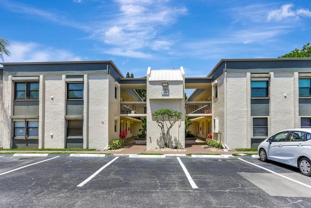 view of apartment building / complex with uncovered parking