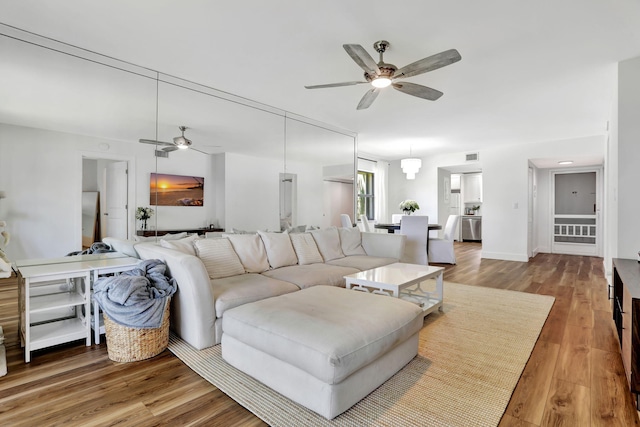 living area with ceiling fan and wood finished floors