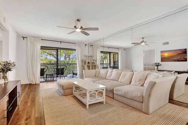 living room with a ceiling fan, wood finished floors, and baseboards