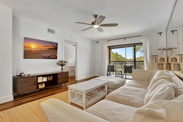 living area featuring wood finished floors, ceiling fan, and baseboards