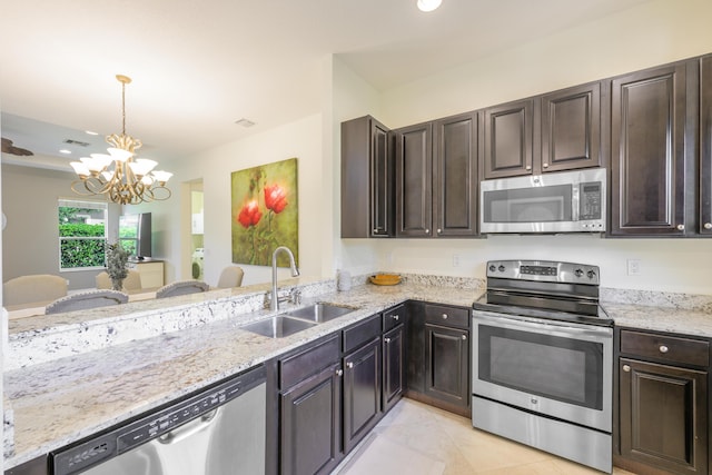 10250 SW Azzo Ln, Port Saint Lucie, FL 34986 - kitchen with stainless steel appliances, a sink, a chandelier, dark brown cabinets, and recessed lighting