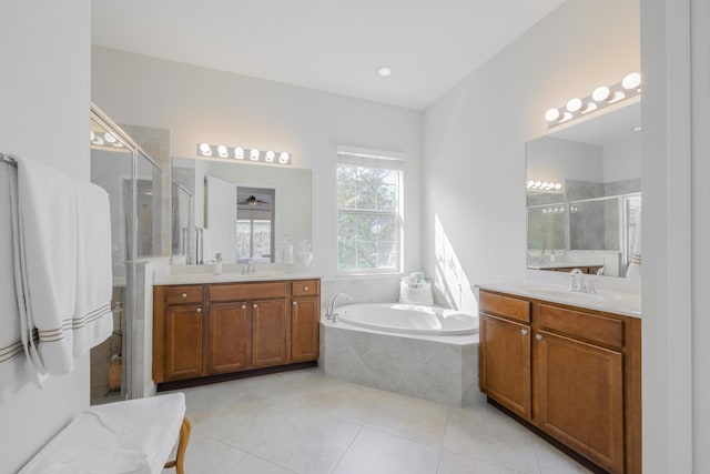 10250 SW Azzo Ln, Port Saint Lucie, FL 34986 - full bathroom with a stall shower, two vanities, a garden tub, and tile patterned floors
