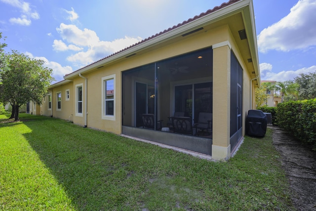 10250 SW Azzo Ln, Port Saint Lucie, FL 34986 - back of house with a sunroom, a yard, and stucco siding
