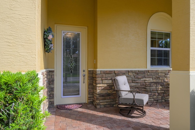 10250 SW Azzo Ln, Port Saint Lucie, FL 34986 - property entrance featuring stucco siding, stone siding, and a patio
