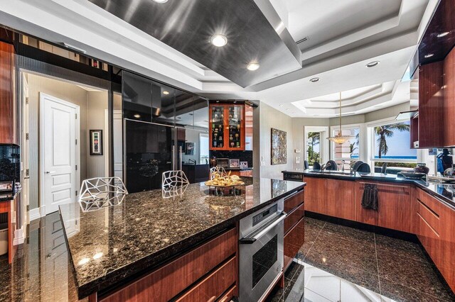 3066 SE Dune Dr, Stuart, FL 34996 - kitchen featuring a raised ceiling, granite tiled floors, recessed lighting, a peninsula, and decorative light fixtures