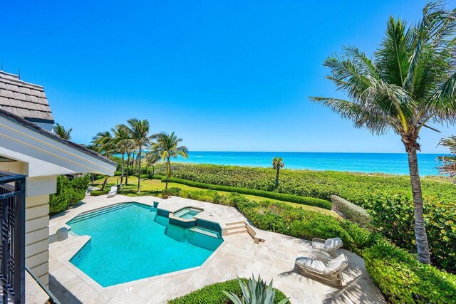 3066 SE Dune Dr, Stuart, FL 34996 - view of swimming pool featuring a water view, a pool with connected hot tub, and a patio area