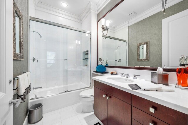 3066 SE Dune Dr, Stuart, FL 34996 - full bathroom featuring ornamental molding, tile patterned floors, combined bath / shower with glass door, vanity, and toilet