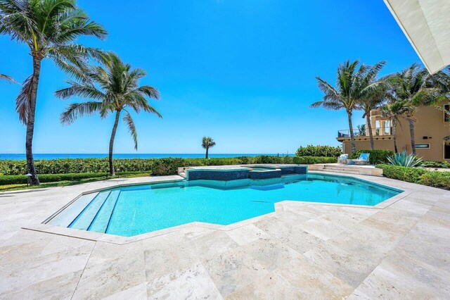 3066 SE Dune Dr, Stuart, FL 34996 - view of swimming pool featuring a patio area, a water view, and a pool with connected hot tub