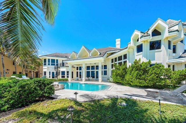 3066 SE Dune Dr, Stuart, FL 34996 - rear view of house featuring an outdoor pool, a chimney, a patio, and stucco siding