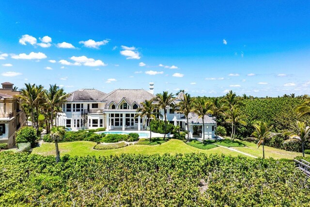 3066 SE Dune Dr, Stuart, FL 34996 - rear view of house featuring a balcony, an outdoor pool, and a lawn