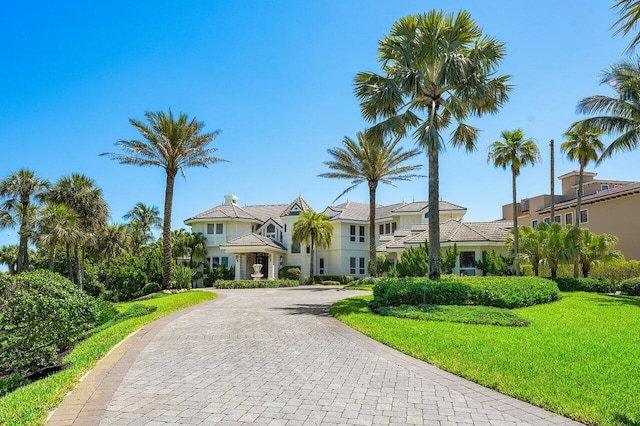 3066 SE Dune Dr, Stuart, FL 34996 - view of front of home featuring curved driveway, a front lawn, and stucco siding