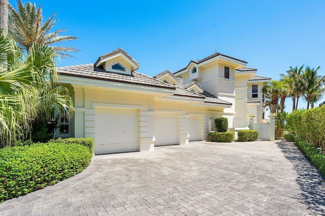 3066 SE Dune Dr, Stuart, FL 34996 - view of front of home featuring an attached garage, decorative driveway, stucco siding, and a tile roof