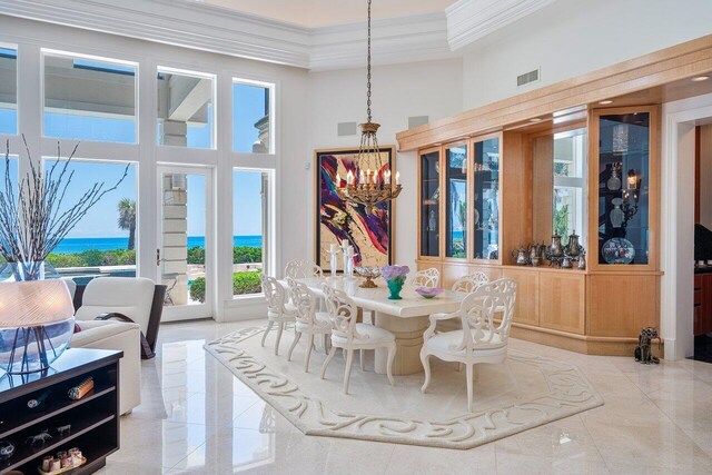 3066 SE Dune Dr, Stuart, FL 34996 - dining area with a towering ceiling, crown molding, and a chandelier