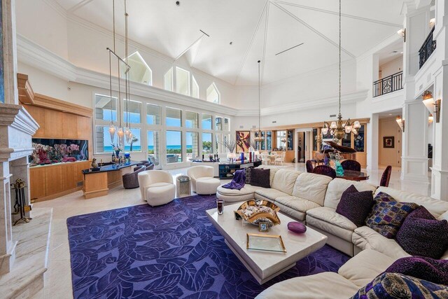 3066 SE Dune Dr, Stuart, FL 34996 - living area featuring a chandelier, a high ceiling, a fireplace, ornate columns, and ornamental molding