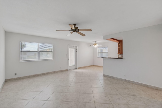 228 Brittany E, Delray Beach, FL 33446 - unfurnished living room featuring healthy amount of natural light, ceiling fan, and light tile patterned flooring
