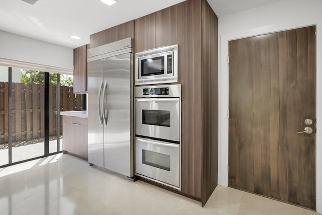 21922 Cypress Dr Unit 37B, Boca Raton, FL 33433 - kitchen featuring built in appliances, modern cabinets, light tile patterned floors, and light countertops