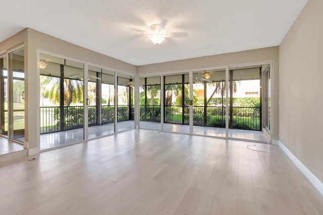 7655 Cinebar Dr Unit 105, Boca Raton, FL 33433 - unfurnished sunroom featuring baseboards and wood finished floors