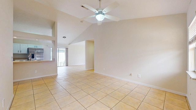 spare room featuring light tile patterned floors, ceiling fan, lofted ceiling, and baseboards