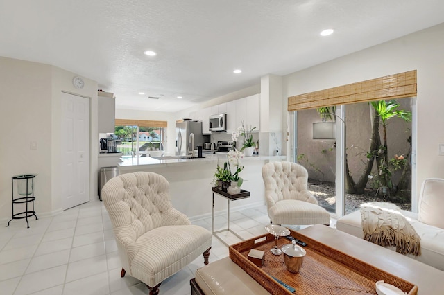 living room featuring recessed lighting, light tile patterned flooring, and baseboards