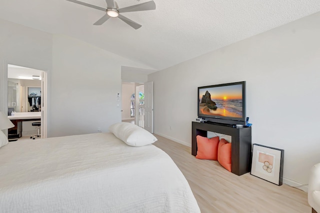 bedroom featuring light wood-type flooring, vaulted ceiling, an office area, ceiling fan, and baseboards