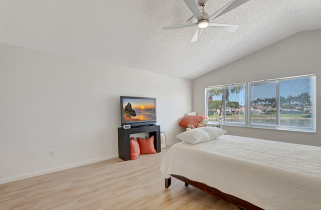 bedroom with a textured ceiling, wood finished floors, lofted ceiling, a ceiling fan, and baseboards