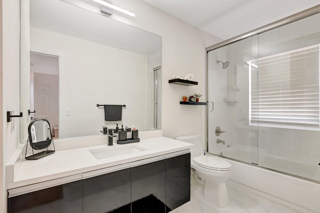 full bath with enclosed tub / shower combo, toilet, vanity, and marble look tile flooring