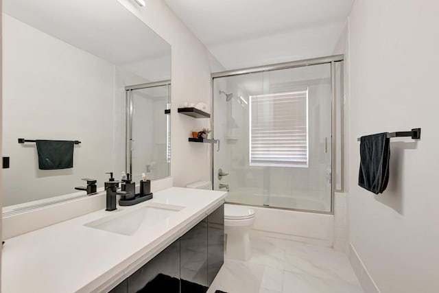 bathroom featuring marble finish floors, toilet, vanity, and bath / shower combo with glass door