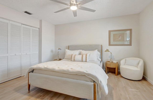bedroom featuring light wood finished floors, a closet, and ceiling fan