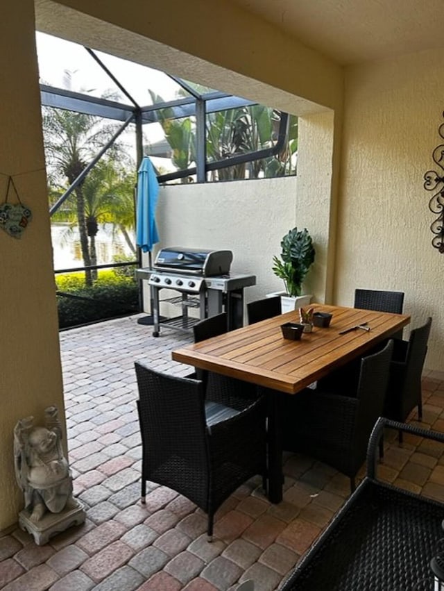 view of patio / terrace with area for grilling, a lanai, and outdoor dining space