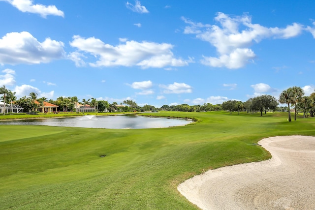 view of property's community with a water view, view of golf course, and a yard