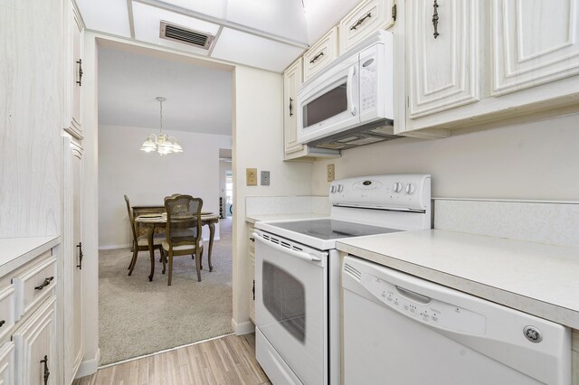 195 High Point Ter E Unit C, Delray Beach, FL 33445 - kitchen with white appliances, light countertops, a chandelier, light wood finished floors, and decorative light fixtures