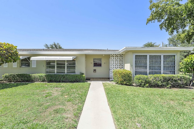 195 High Point Ter E Unit C, Delray Beach, FL 33445 - view of front facade with stucco siding and a front yard